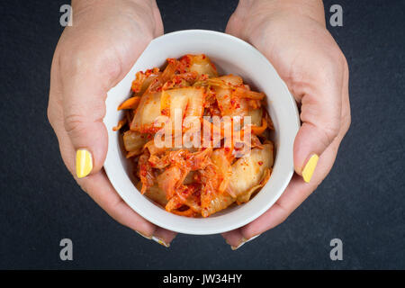 Kimchi - Koreanische superfood. Eingelegte Chinakohl in Schüssel auf schiefer Platte Stockfoto