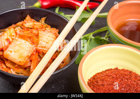 Kimchi - Koreanische superfood. Eingelegte Chinakohl in Schüssel auf schiefer Platte Stockfoto