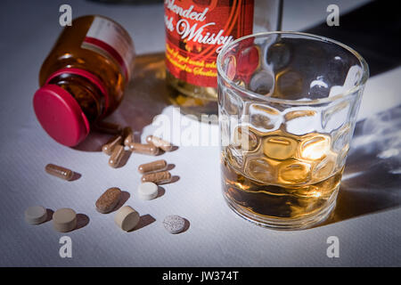 Whiskey Glas mit Pillen, Konzept des Alkoholismus Stockfoto