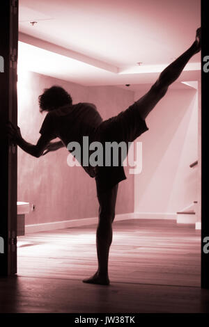 Männliche Yogalehrer tun teilt Bein Strecken Flexibilität Gymnastik und Yoga Asanapraxis im Fitness-Studio Stockfoto