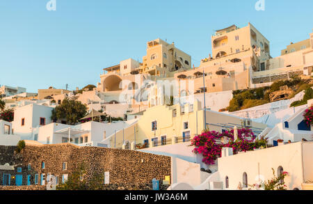 Weiß getünchtes cliffside Häuser und Apartments in Perissa, einem Dorf in der Nähe der Fira auf der griechischen Insel Santorin, im Licht der untergehenden Sonne am Abend Stockfoto