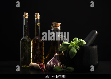 Infundiert Olivenöl, Kräutern und Gewürzen auf dunklem Stein Hintergrund Stockfoto