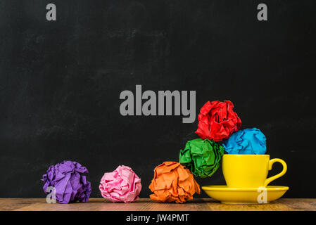 Bunte Kugeln von Junk-Papier gelb heißen Kaffee Tassen Gruppe fiel aus und in Holz Textur retro Boden zeigen Blackboard Hintergrund angeordnet. Stockfoto