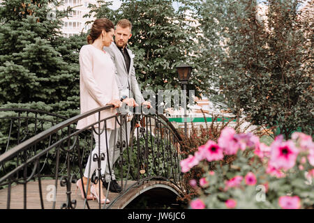 Junge schöne Paar Fuß in den Park und steht auf der Brücke Stockfoto