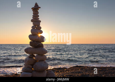 Sunbeam bei Sonnenuntergang durch einen steinernen Pyramide von der Meerseite Stockfoto