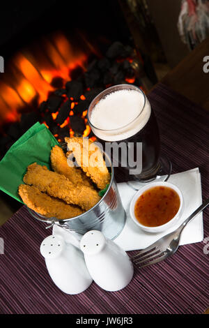 Ein Pub/Restaurant Lunch/Snack von heiß und würzig panierte Hähnchenfilets mit einem Sweet Chili Dip und ein Glas Bier. Stockfoto