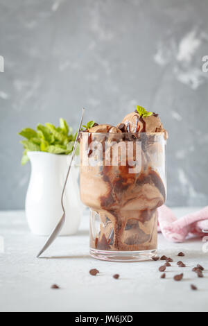 Hausgemachten Schokoladeneis mit Sirup und Schokolade fällt. Liebe für eine gesunde vegane Ernährung Konzept. Stockfoto