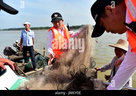 (170811) - ANQING, Aug 11, 2017 (Xinhua) - Aux Streifenpolizisten prüfen das Fischernetz auf einem Boot in der finless porpoise Naturschutzgebiet in Anqing der ostchinesischen Provinz Anhui, 10.08.2017. Eine Patrouille der Feuerwehr, darunter 6 sind ehemalige Fischer, ihre Mission im Juni 2017 begann der Schutz der 60 finless Schweinswale entlang der 60 Kilometer langen Abschnitt der Yangtze Fluss in der Provinz. Telefon Anwendung ist in ihrer Routine Missionen eingesetzt zu verfolgen und die Delfine beobachten - wie die Säugetier leben, notwendigen Schutz bieten und die Schadstoff- und illegale Fischerei in der Reserve zu überwachen. (Xinhu Stockfoto