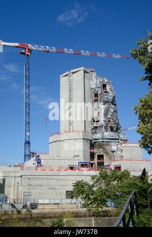 Arles, Frankreich. 11 August, 2017. Frank Gehry Tower nimmt Gestalt in Arles. Eines der neuesten Projekte, die von führenden amerikanischen Architekten Frank Gehry, ist die Form in Arles, für seine jährliche "Rencontres" Foto Festival bekannt, im Süden von Frankreich. Steigende 58 Meter über dem niedrigen Stadt Wahrzeichen, das Gebäude besteht aus einem unregelmässigen Turm verkleidet in poliertem Stahl und Glas. Fertigstellung im nächsten Jahr, wird der Turm Haus eine experimentelle Arts Center, 'LUMA Arles', der Schweizer Philanthrop Maja Hoffmann finanziert. Quelle: Chris Hellier/Alamy leben Nachrichten Stockfoto