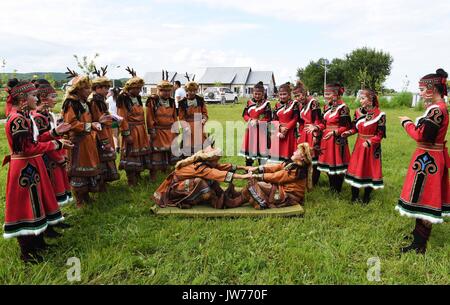 Xunke, Heilongjiang Provinz Chinas. 11 Aug, 2017. Oroqen Athleten konkurrieren in der Ziehen-a-stick Match beim Sport Wettbewerb der traditionellen Gott der ethnischen Gruppe der Brand Opfer Festival in Xunke County, im Nordosten der chinesischen Provinz Heilongjiang, Aug 11, 2017. Die Gulunmuta Festival, das wichtigste Festival für die oroqen Menschen, wurde als einer der ersten Charge von Chinas immaterielle Kulturerbe im Jahr 2006 aufgeführt. Credit: Wang Jianwei/Xinhua/Alamy leben Nachrichten Stockfoto