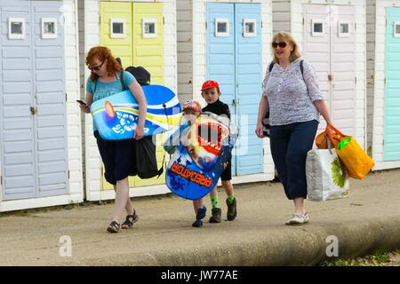 Lyme Regis, Dorset, Großbritannien. 12 Aug, 2017. UK Wetter. Eine Familie zu Fuß entlang der Strandpromenade unter schwach diesig Sonnenschein in den Badeort Lyme Regis in Dorset mit all ihren Gang für einen Tag am Strand. Credit: Graham Jagd-/Alamy leben Nachrichten Stockfoto
