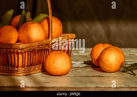 Korb mit frisch in der Saison Orangen auf hölzernen Tisch abgeholt Stockfoto