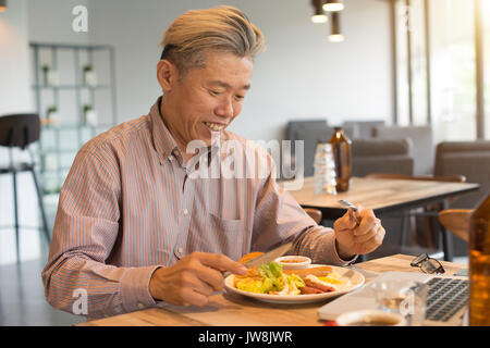 Gereift Asian Business männlichen Frühstück Stockfoto