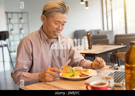 Gereift Asian Business männlichen Frühstück Stockfoto