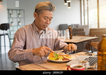 Gereift Asian Business männlichen Frühstück Stockfoto