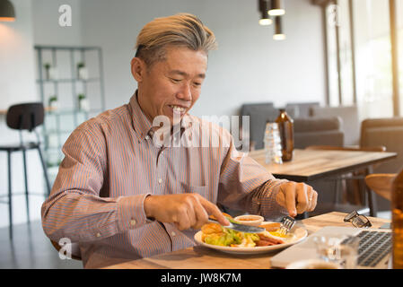 Gereift Asian Business männlichen Frühstück Stockfoto