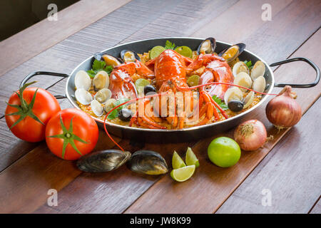 Gourmet Meeresfrüchte Valencia Paella mit frischen Scampi, Muscheln, Muscheln und Tintenfisch auf herzhafte Safran Reis mit Erbsen und Zitronenscheiben, Ansicht schließen Stockfoto