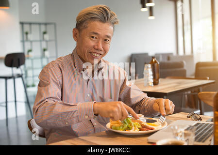 Gereift Asian Business männlichen Frühstück Stockfoto