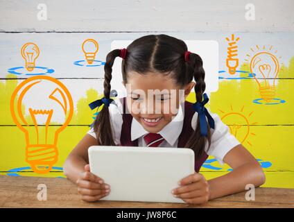 Digital composite von Schulmädchen auf Tablet mit bunten Glühbirne Grafik Stockfoto