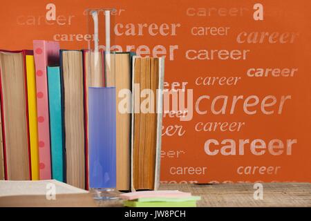 Digital composite der Bücher auf den Tisch gegen orange Tafel mit Karriere text Stockfoto