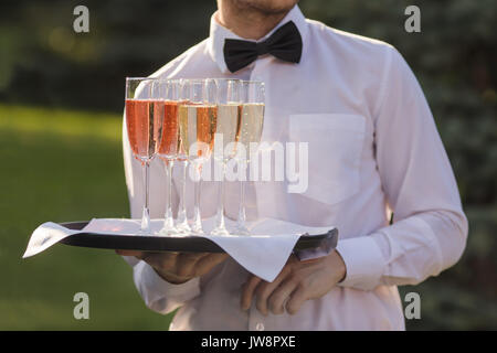 Kellner Champagner auf einem Tablett serviert Stockfoto