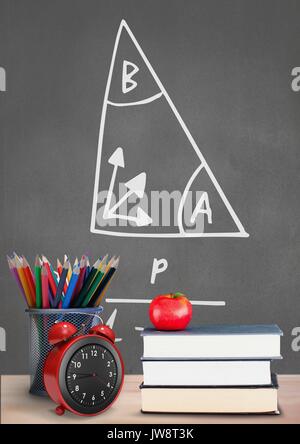 Digital composite der Bücher auf den Tisch gegen Grau Tafel mit Bildung und Schule Grafiken Stockfoto