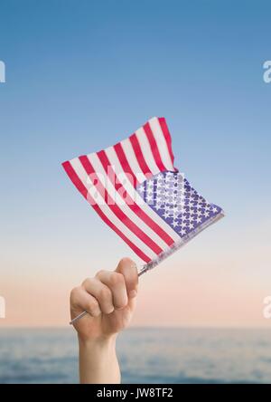 Digital composite der Person, die im Besitz einer USA-Flagge in den Strand Stockfoto