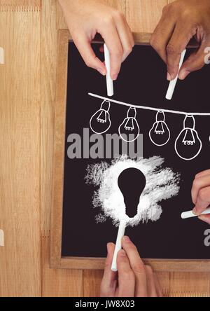 Digital composite der Hände zeichnen Glühlampen auf blackboard Stockfoto