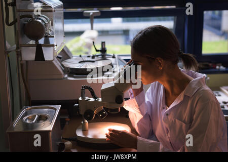 Weibliche Studenten mit Mikroskop beim Üben Experimentieren im Labor Stockfoto