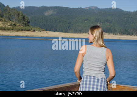 Ansicht der Rückseite des weiblichen Wanderer durch Geländer am Pier gegen Berg Stockfoto