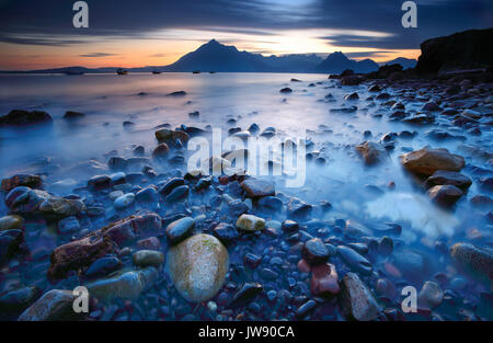 Die Cuillin Mountains von Elgol, Isle of Skye, mit den bunten abgerundeten Steine im Vordergrund. Stockfoto