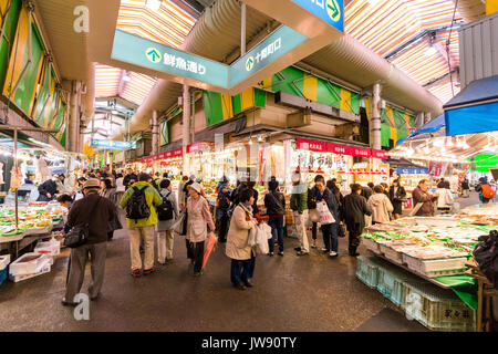 Viel befahrenen Kreuzung im Hallenbad Food Market, Omicho, Kanazawa, Japan. Zwei Gänge überschneiden, mit verschiedenen frischen Ständen gesäumt, besetzt mit Kunden. Stockfoto