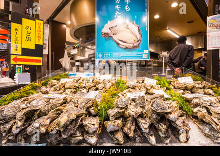 Japan, Kanazawa. Omi-cho frische Lebensmittel Markthalle. Frischen Fisch. Schalentiere, Muscheln und Austern im Stapel mit Preis Zeichen auf gestapelt. Stockfoto