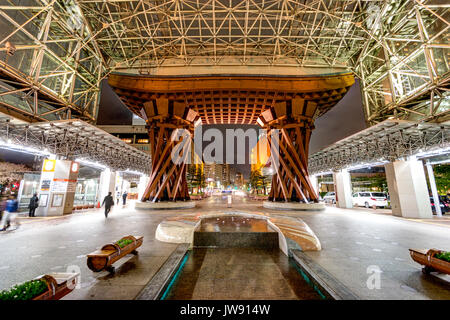 Kanazawa Station, Japan, Glas Motenashi Dome Innenraum bei Nacht, mit zentralem Wasserspiel, nur wenige Menschen. Tsuzumi tor Trommel in den Hintergrund. Stockfoto