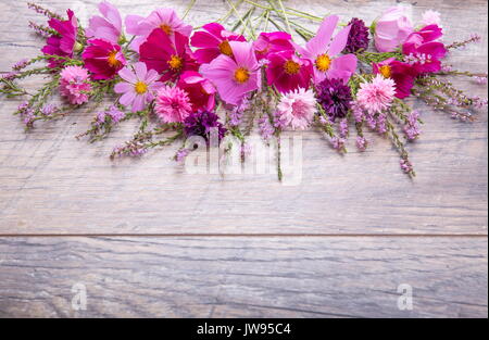 Rosa und Lila Blumen cosmea oder Cosmos und Kornblumen, Heidekraut auf rustikalen hölzernen Brettern. Kopieren Sie Platz. Mutter, Valentines, Frauen, Hochzeit conc Stockfoto