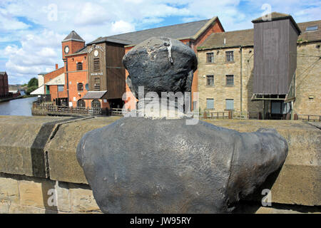 Skulptur von einem Kanal Boot Arbeiter oder 'Bargee' mit Blick auf die Leeds & Liverpool Canal an Wigan Pier Stockfoto