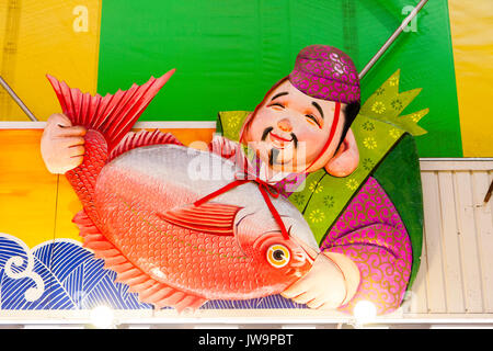 Japan, Kanazawa. Omi-cho frische Lebensmittel Markthalle. Frischer Fisch abgewürgt. Zeichen über Speichern, Ebisu, japanischen Gottes der Fischer, der große orange Fisch. Stockfoto