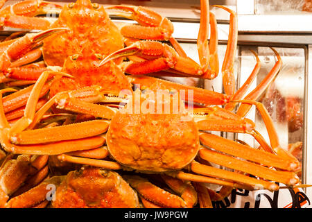 Japan, Kanazawa. Omi-cho frische Lebensmittel Markthalle. Frischen Fisch. Orange große Krabben im Container zum Verkauf. Stockfoto