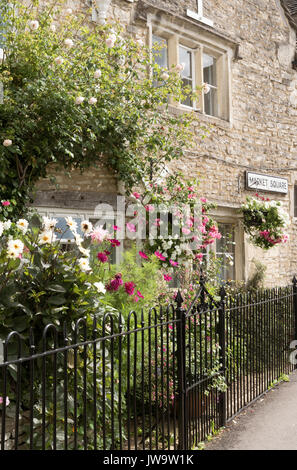 Bunte Blumen bedecken die Wand von einem Cotswold aus Stein gebaute Haus in Minchinhampton Gloucestershire, Großbritannien Stockfoto