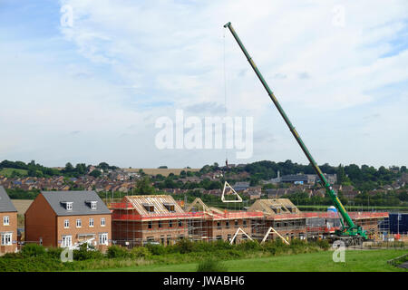 Kran ein Dach eines Frames auf eine neue Wohnsiedlung, Grantham. Lincs, England, Großbritannien Stockfoto