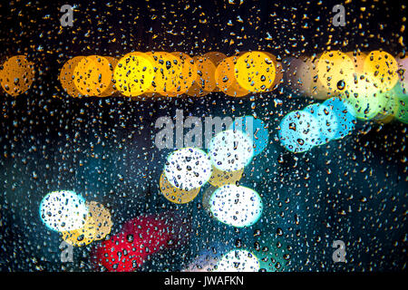 Regentropfen auf Fenster mit Bokeh des Lichts. Stockfoto