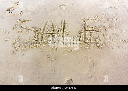 Verkauf in den Sand geschrieben am Sunset Beach. Business Topic Stockfoto