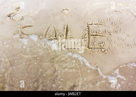 Verkauf in den Sand geschrieben am Sunset Beach. Business Topic Stockfoto
