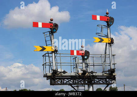 Satz von semaphore Signale auf einem Gantry an einem Ende von Worcester Shrub Hill Bahnhof gegen eine überwiegend blauen Himmel gesehen. Stockfoto