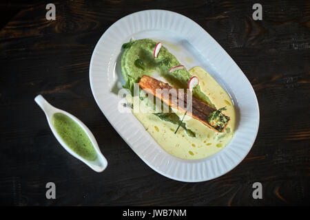 Gebackene Forelle mit Sauce und Brokkoli Stockfoto