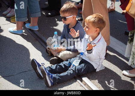 TALLINN, Estland - 04 May 2014: Zwei kleine Jungs aufpassen feierliche Prozession der Estnischen Lied und Tanz Festival Stockfoto