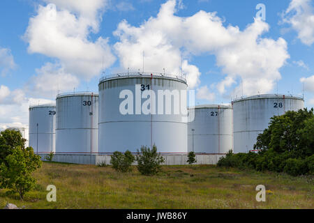 Silber Öltanks auf der grünen Wiese. Blauer Himmel mit Wolken. Stockfoto