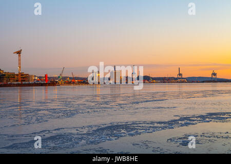 Sonnenuntergang über eine Industrie Hafen mit Kränen in Norwegen. Stockfoto