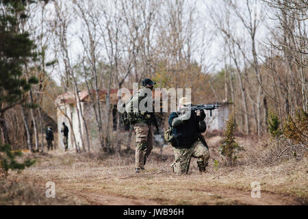 HUMALA, ESTLAND - 09 APR 2016: Zwei Soldaten in der Tarnung mit Waffen, ihre Position zu schützen. Taktische airsoft Spiel. Stockfoto