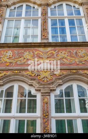 Alte Hausfassade mit Fenstern mit Malerei und gold Monogramme. Im deutschen Stil. Stockfoto